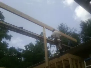 Carpenter setting a ridge beam over a new addition frame — Ice Dam Removal by Roofing Brothers in Point Roberts