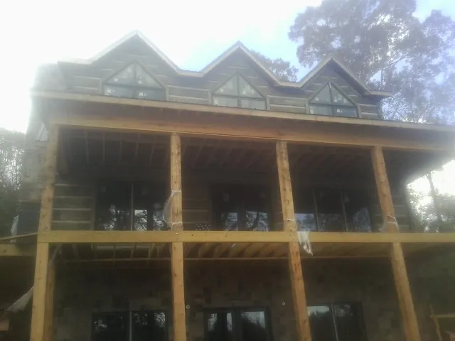 Dormers and porch framing on a large log home under construction — Roof Coating work by our crew in Point Roberts